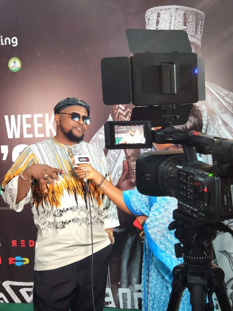 Drtonez on the black carpet at Africa Fashion Week Lagos 2025, during an interview and paparazzi moment as a featured panelist.
